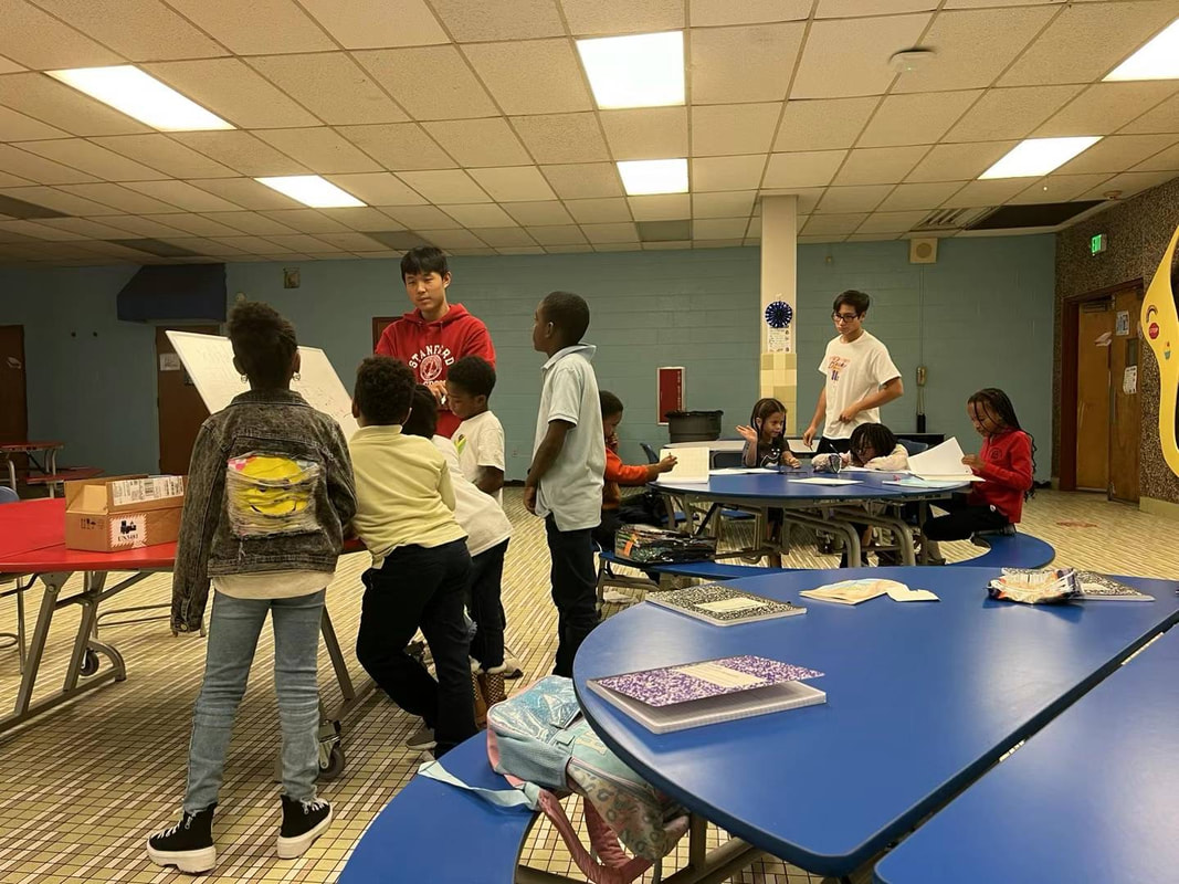 Two tutors teaching students at Baltimore International Academy West