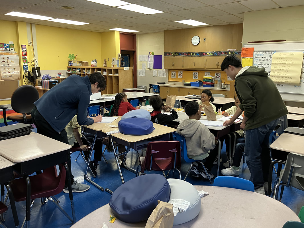 Two tutors teaching students at Baltimore International Academy West
